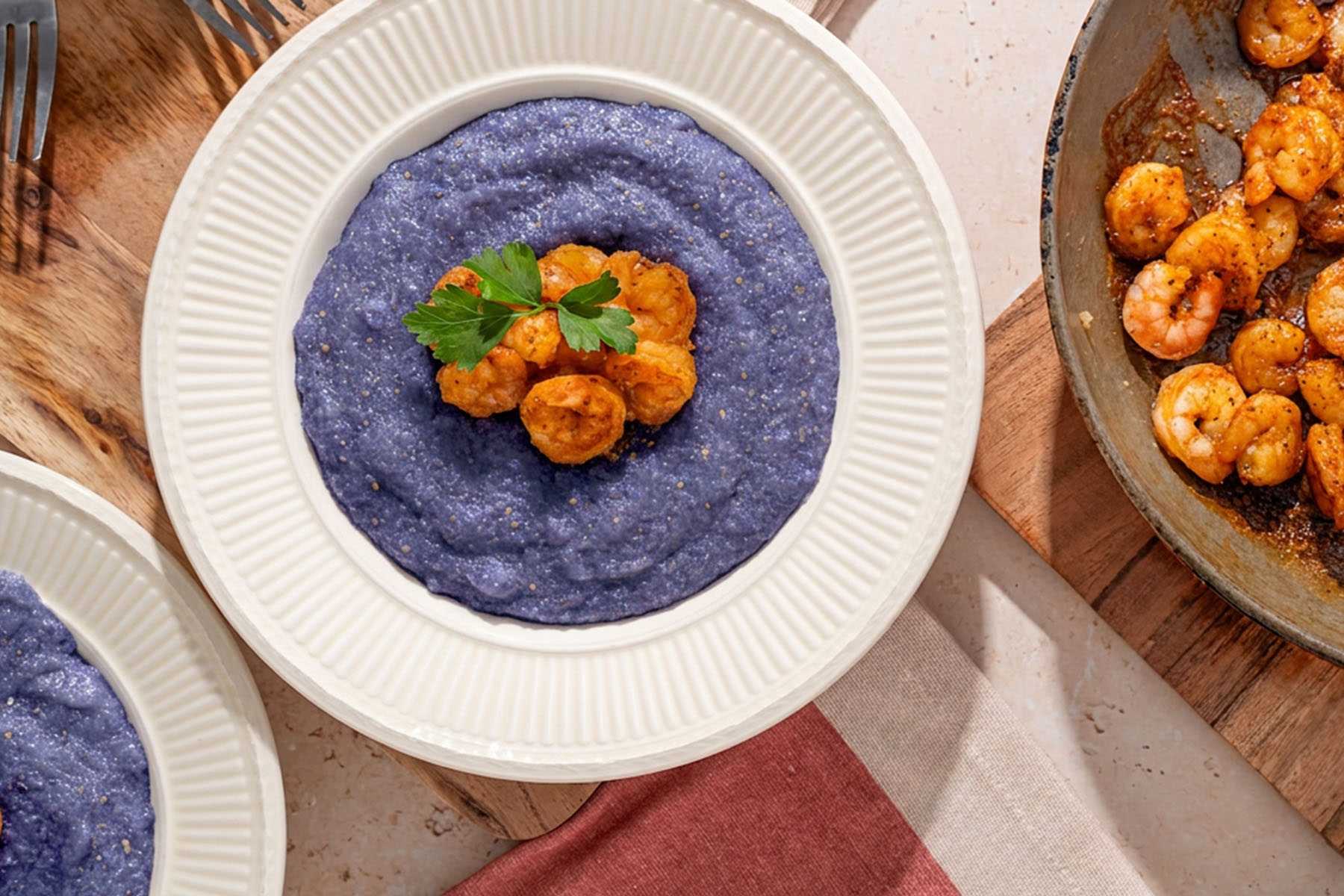 a bowl of grits with shrimp on top