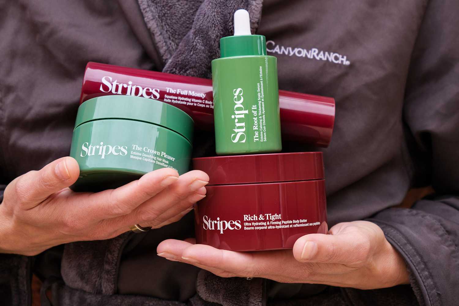 A Woman in Bathrobe Holding Stripes Beauty Products