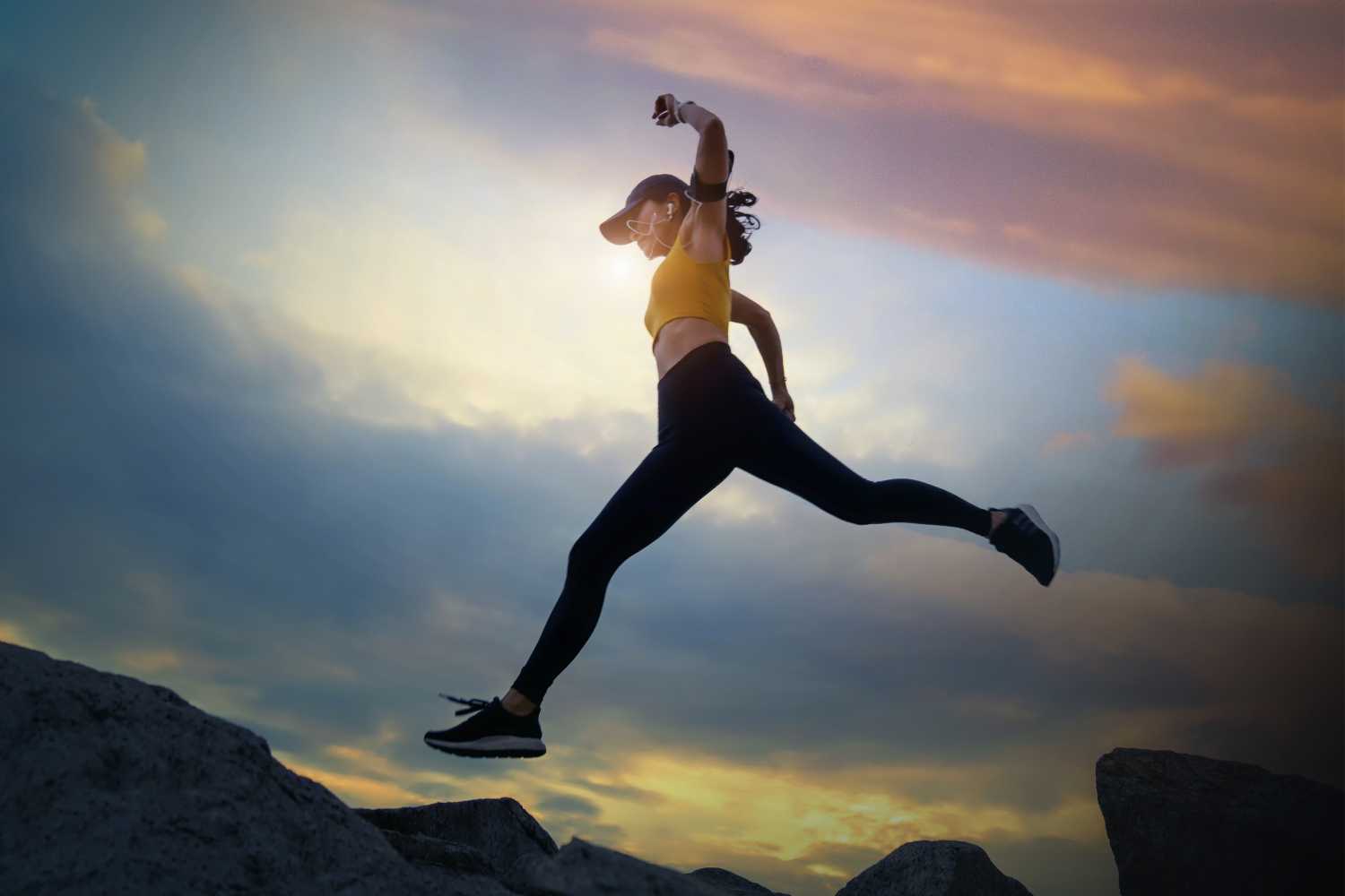 a woman jumping over a canyon