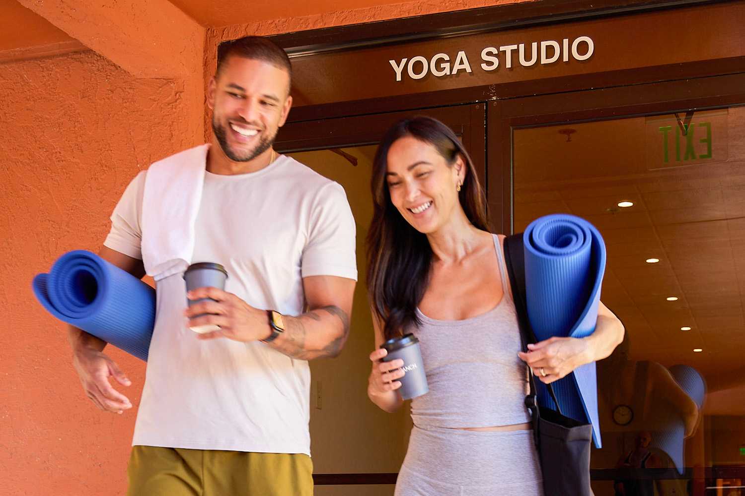 Man and Woman Walking to Yoga With a Cup of Coffee in Their Hands 