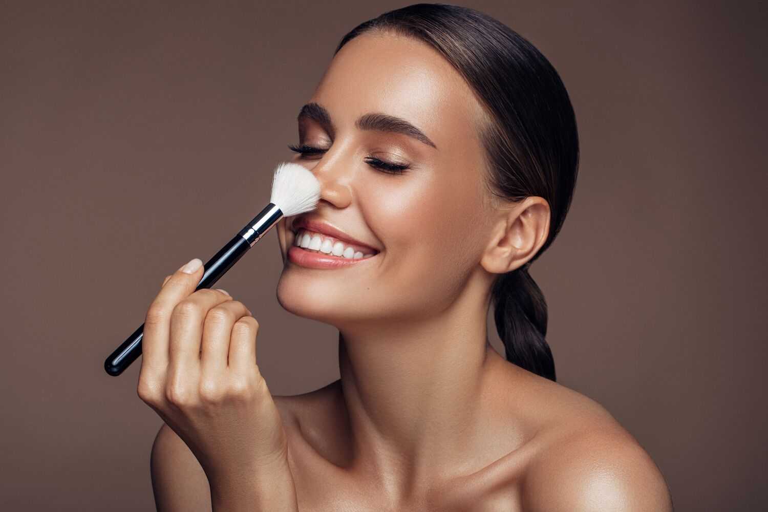 Woman Smiling with Make Up Brush on Her Face