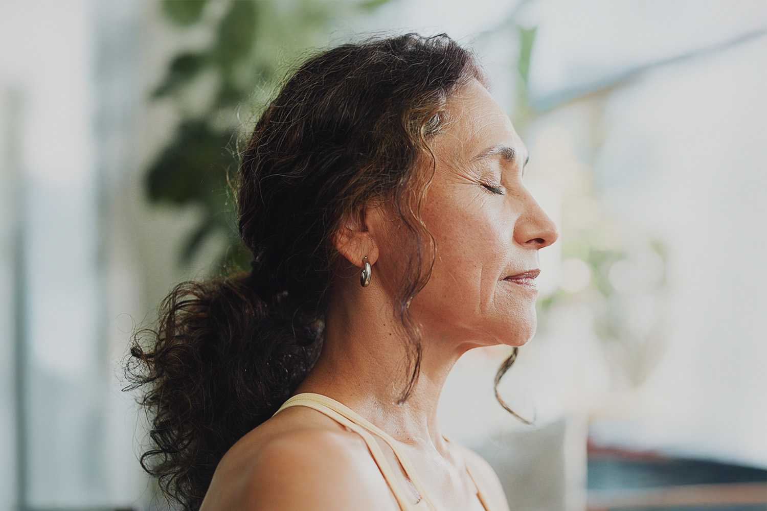 Woman Meditating in Front of a Window 