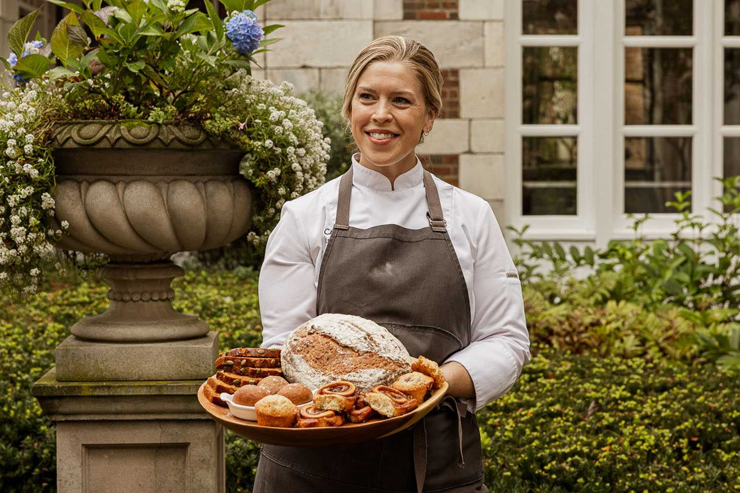 Chef April Franqueza With Baked Goods on a Platter