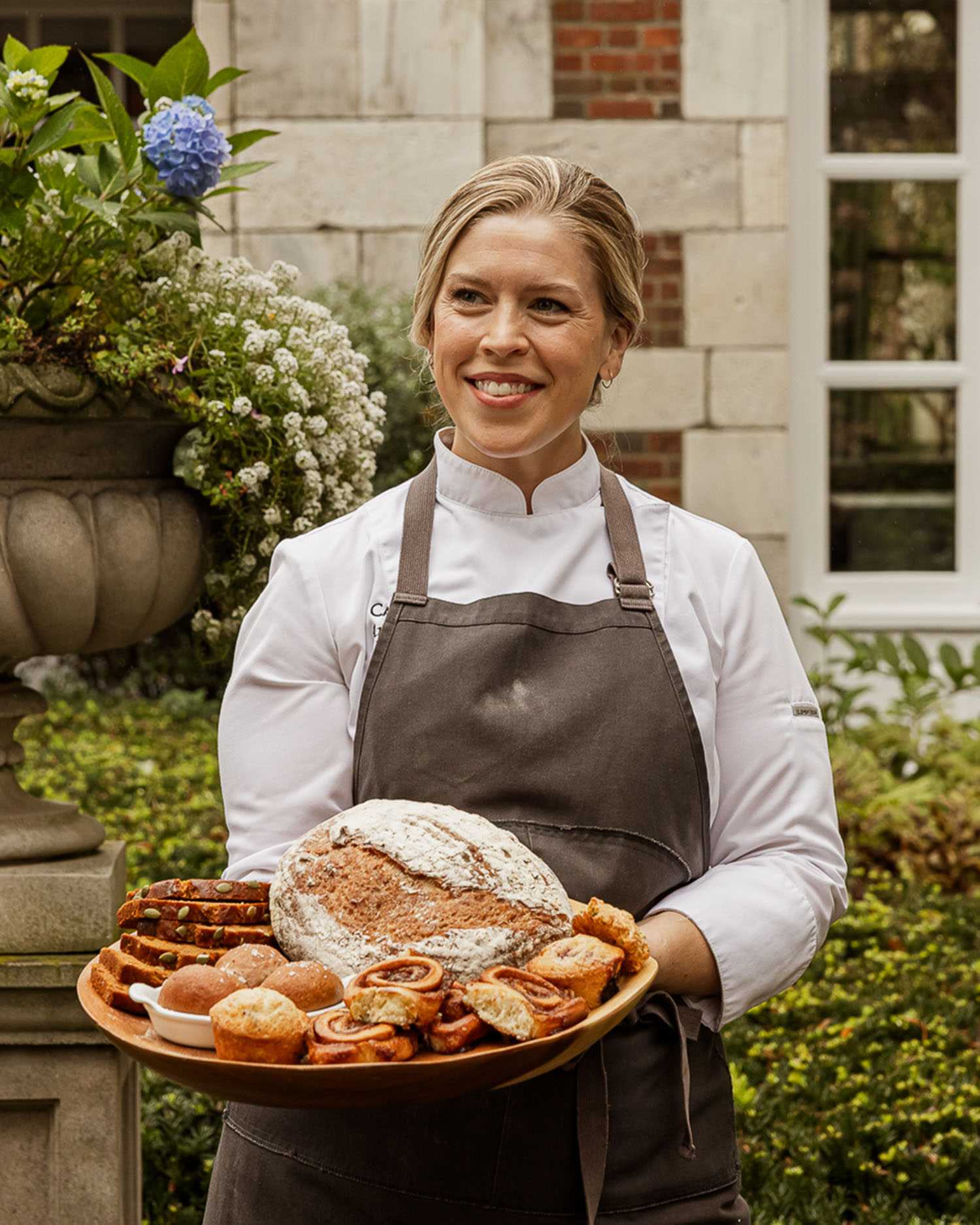 Chef April Franqueza With Baked Goods on a Platter