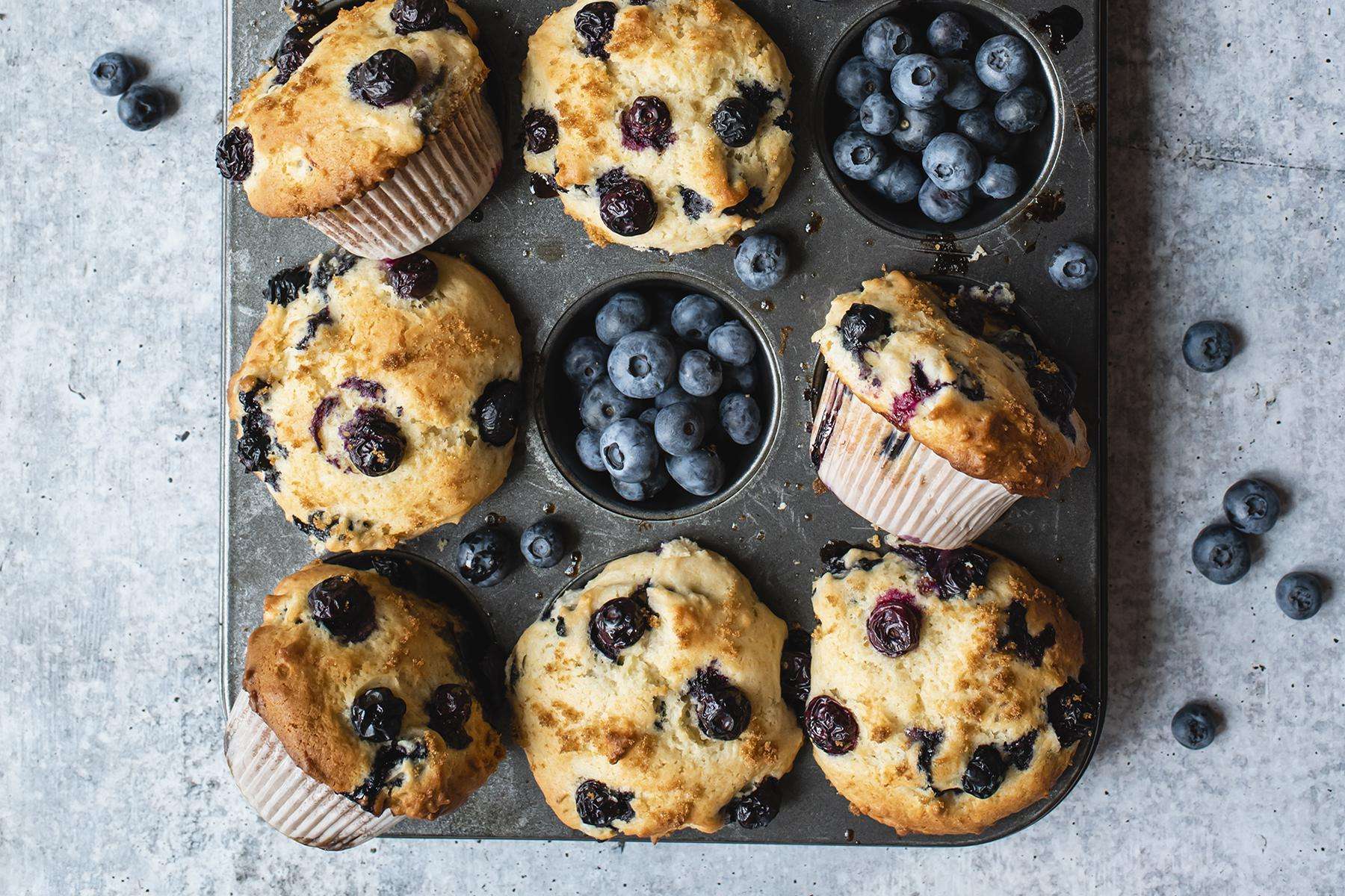 Cooked blueberry muffins in muffin pan.