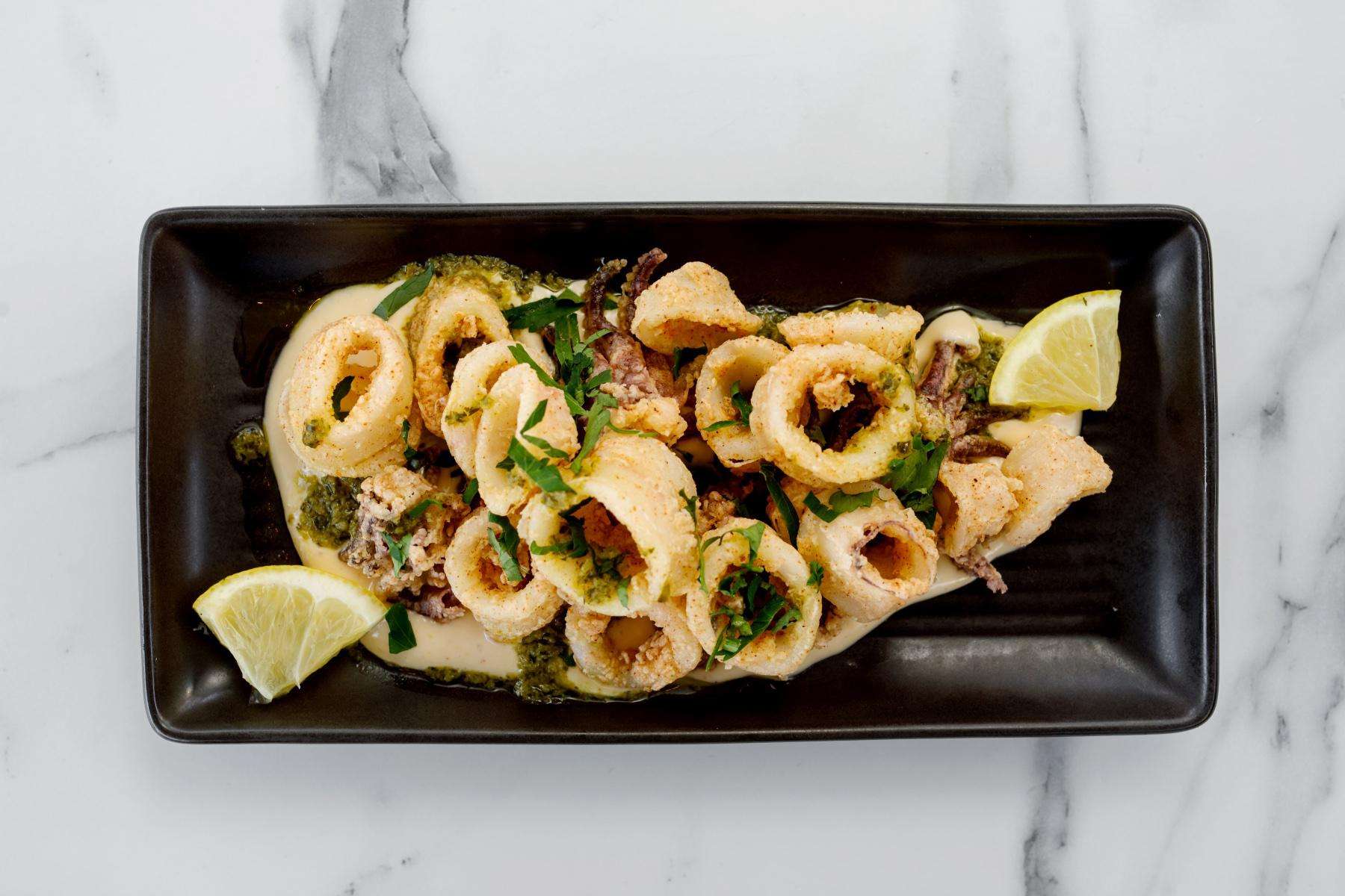 Overhead view of a black plate covered with calamari.