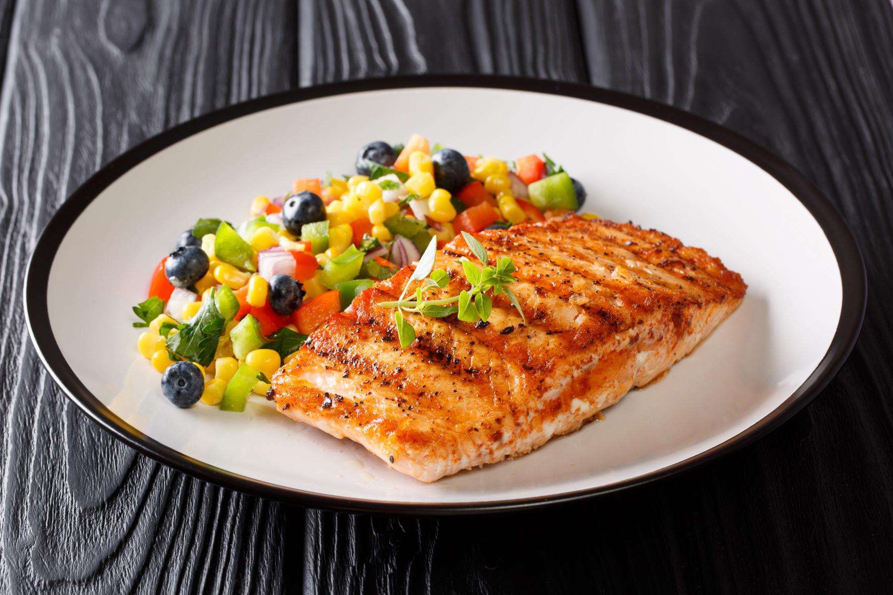 Plate of cooked salmon with blueberry mango salsa.