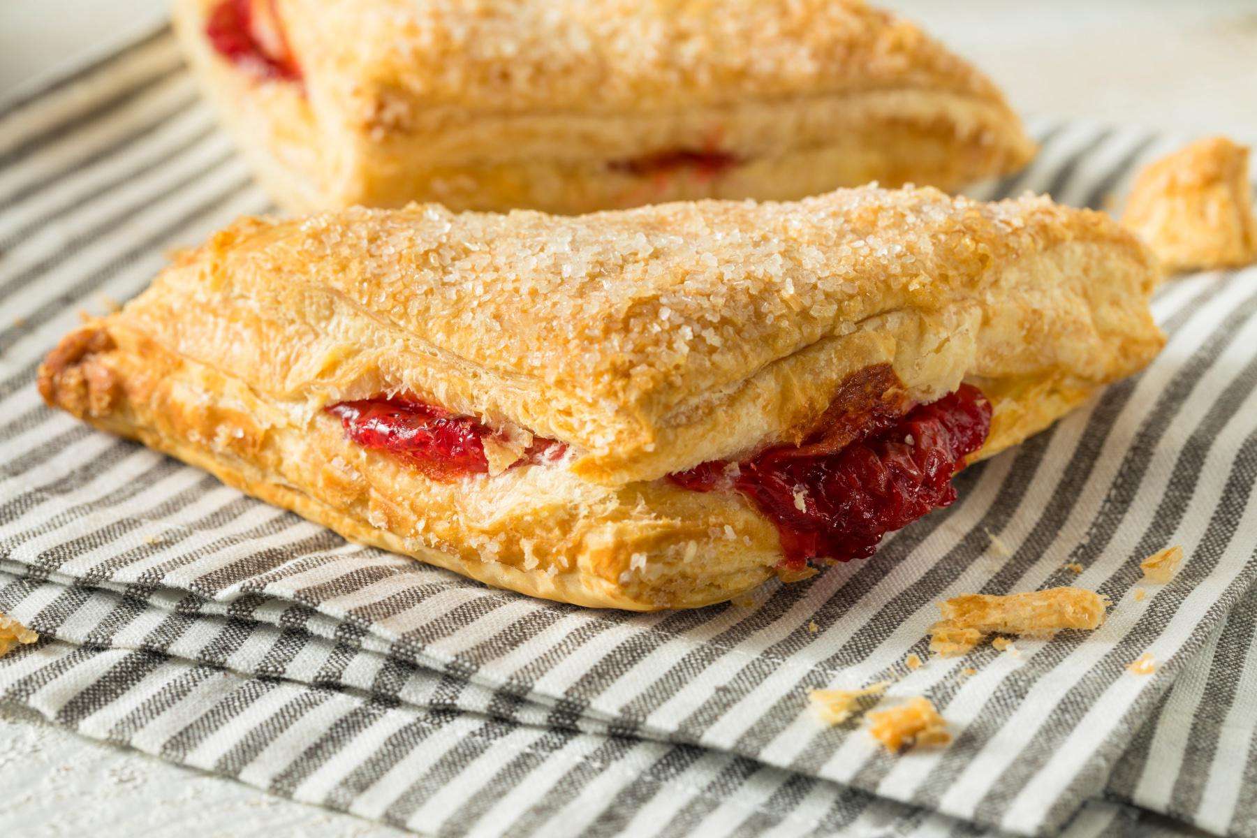 Strawberry rhubarb triangle on a blue and white striped napkin.