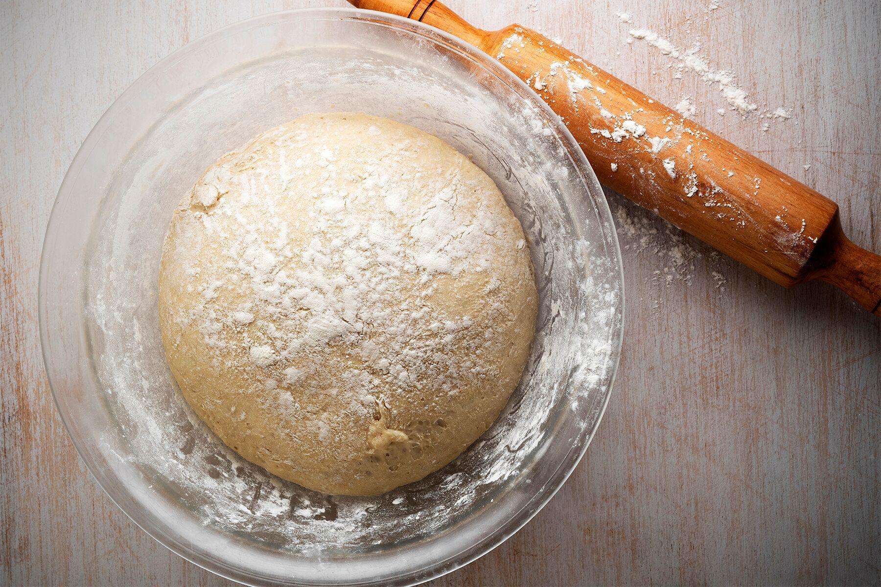 A bowl of whole wheat pizza crust left to rise