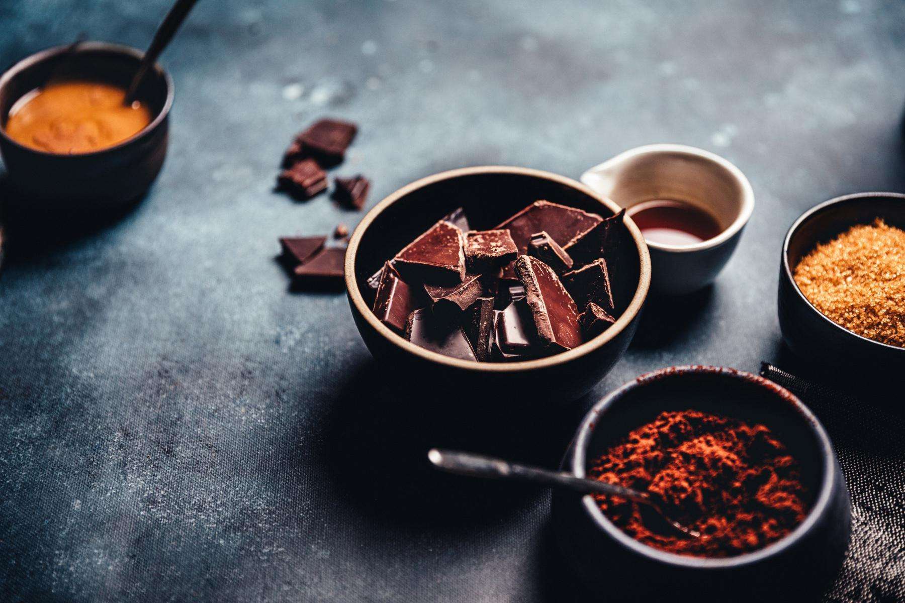 Various bowls of chocolate, cardamom, and other spices.