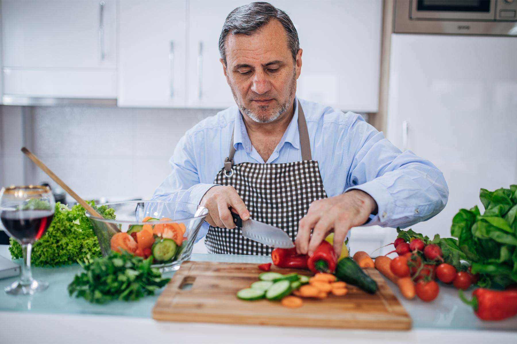 Close-up image of man chopping vegetables.