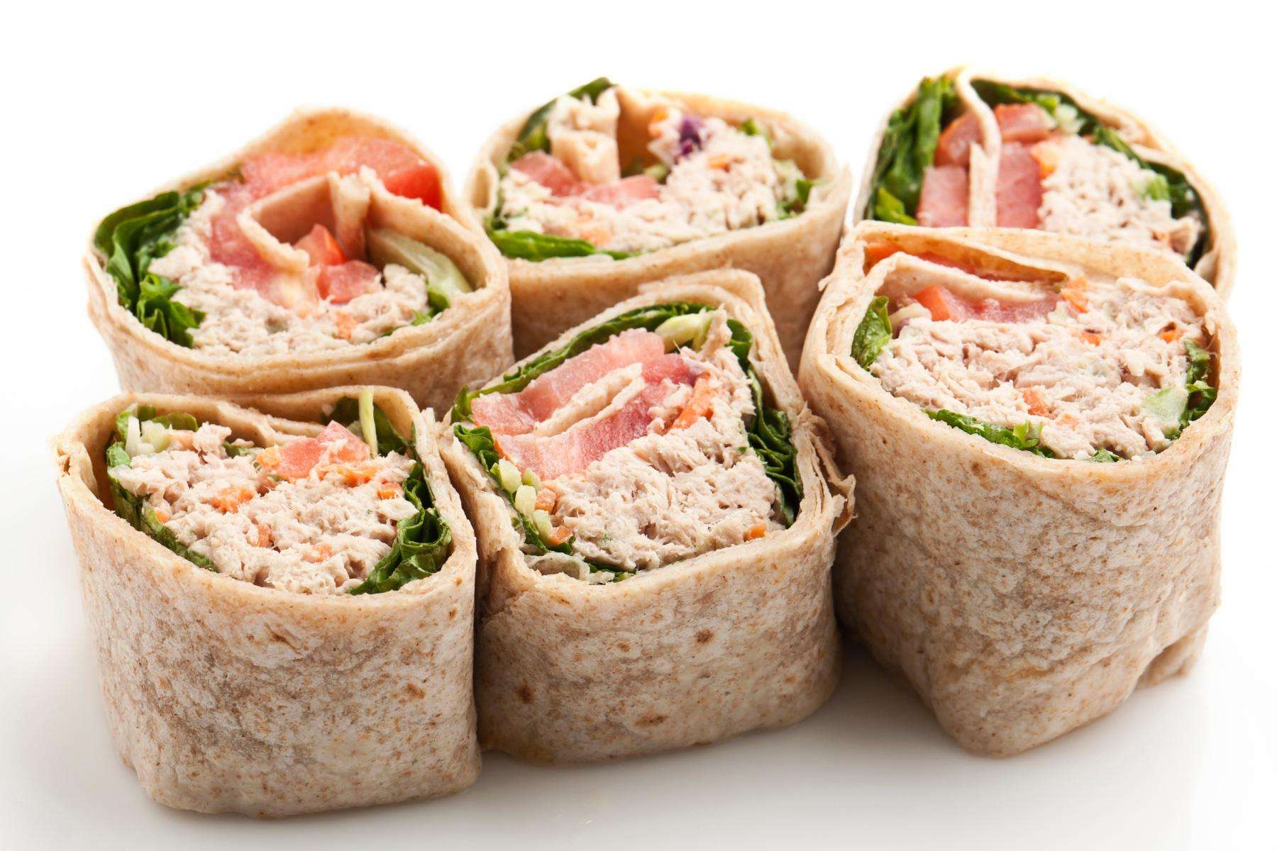 Overhead view of tuna salad wraps cut in half.
