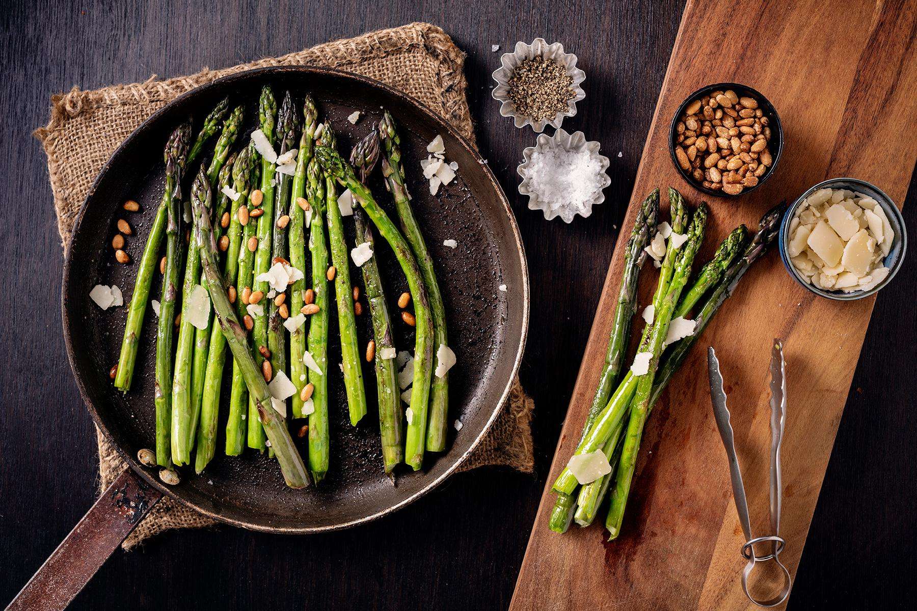 Asparagus cooking in a cast iron pan.