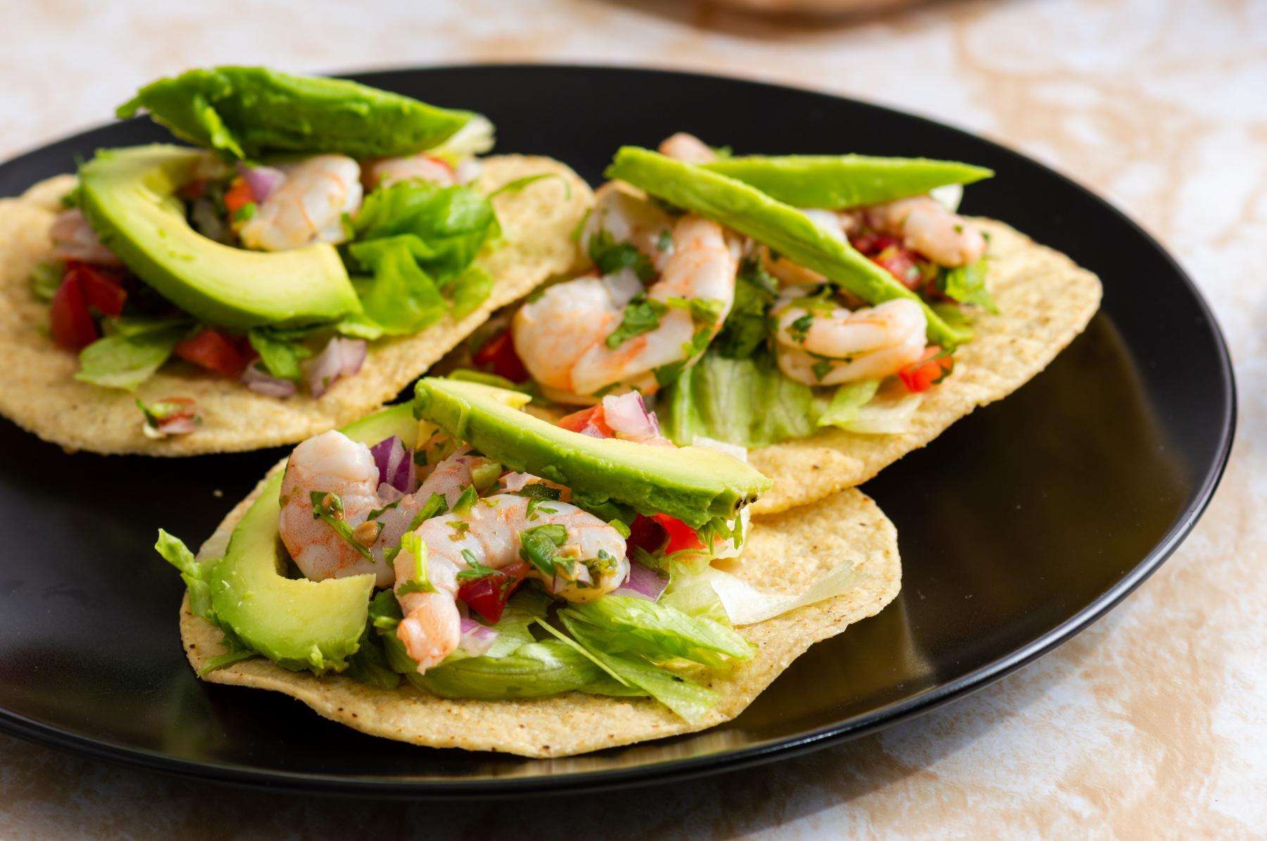 A plate of three shrimp tostadas.