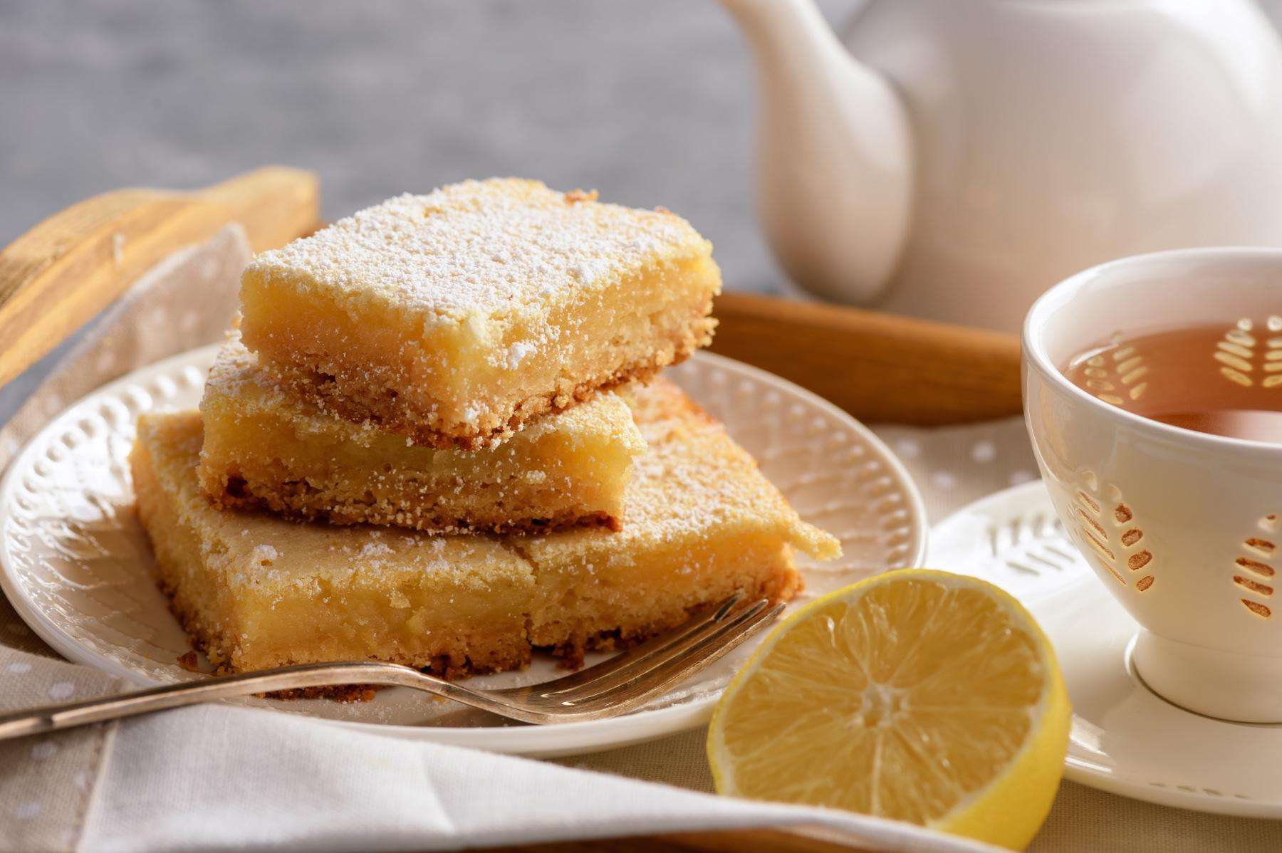 Lemon bars on tray with cup of tea.