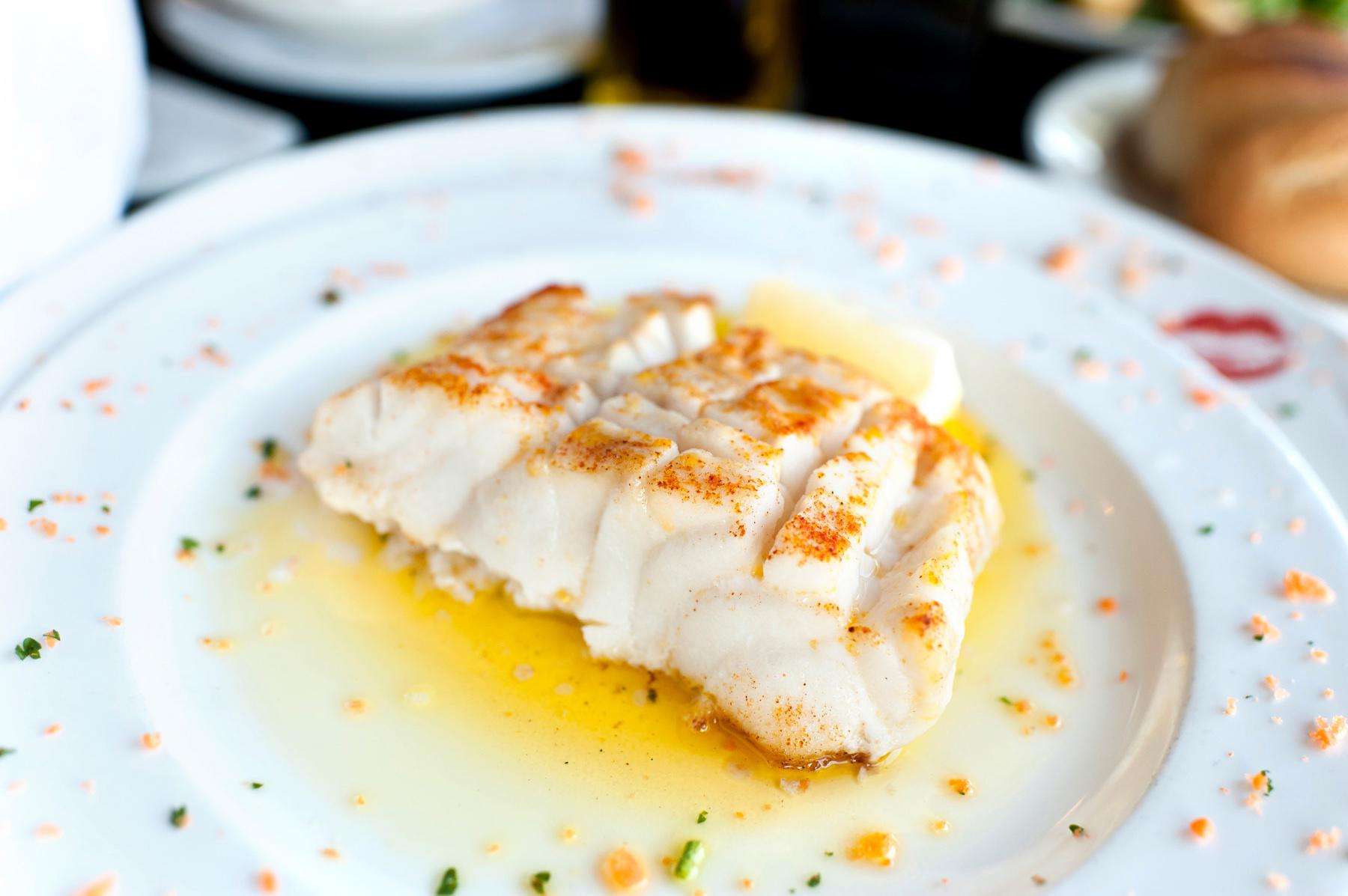 Sautéed sea bass on white plate.