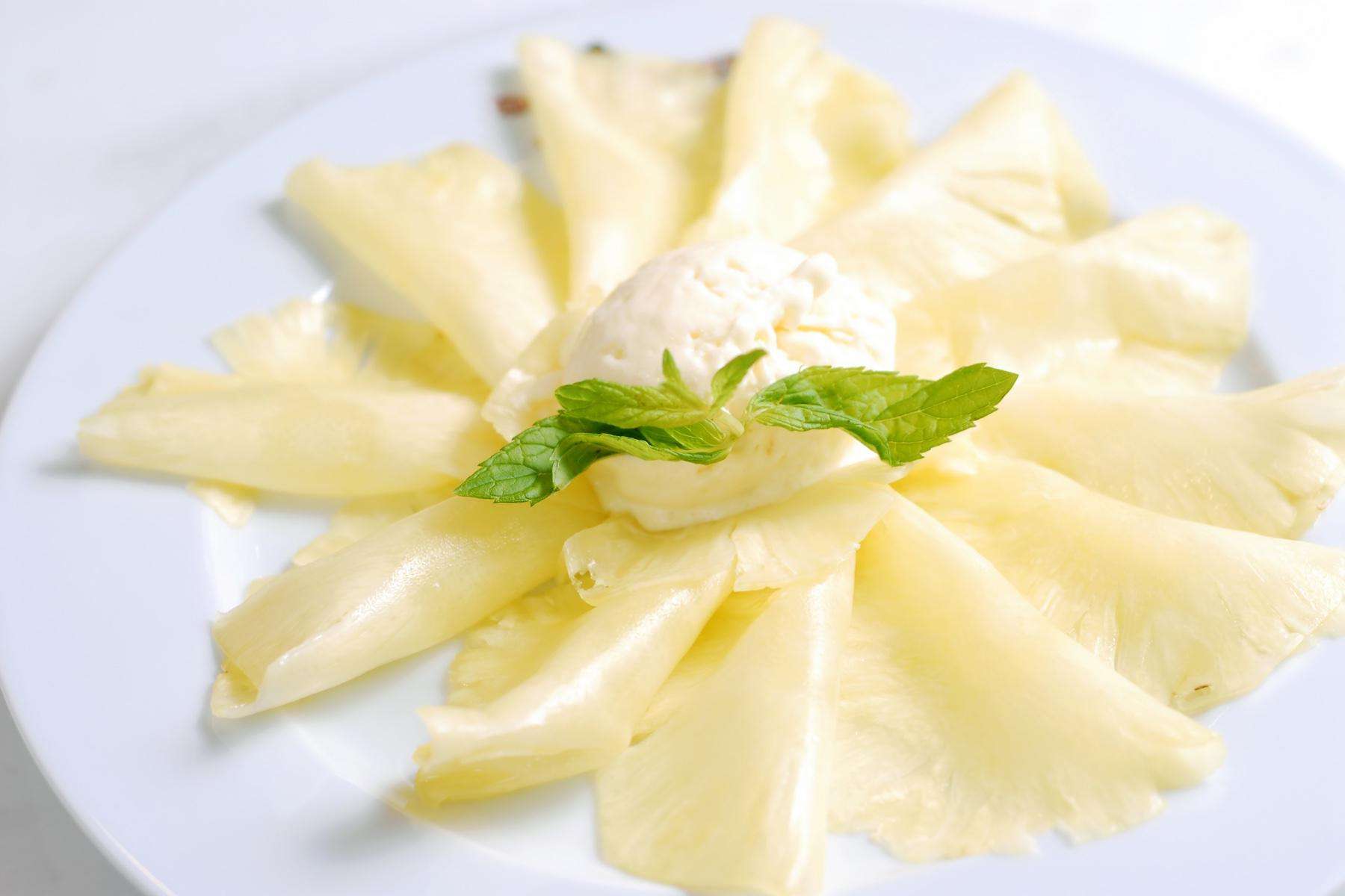 Thinly sliced pineapple on plate.