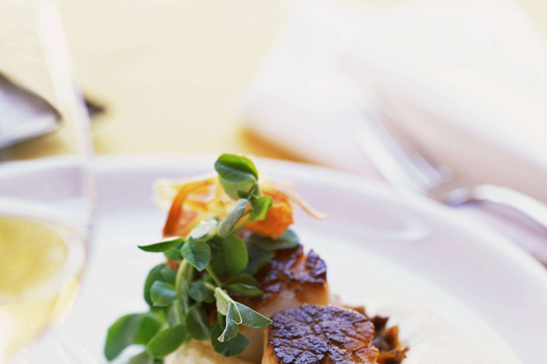 Close-up of seared scallop with wasabi oil.