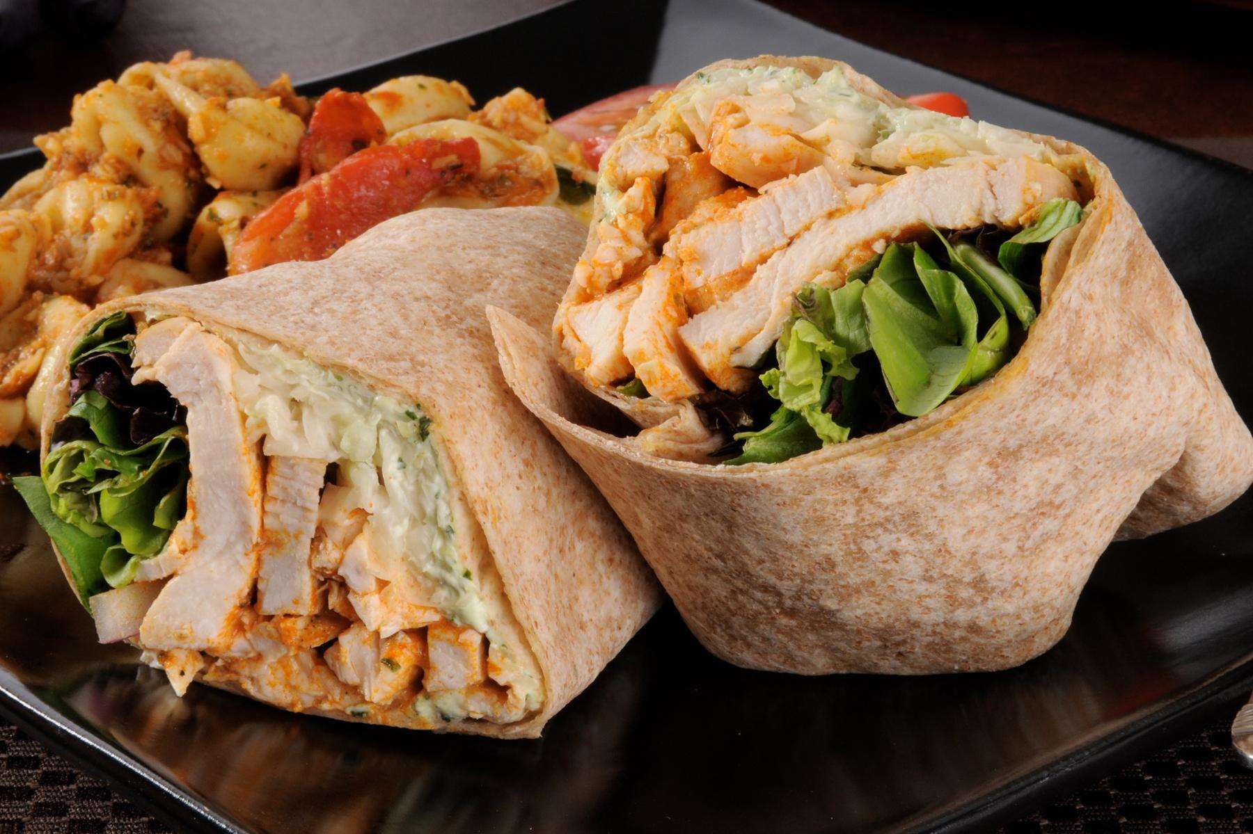 Close-up of a mediterranean chicken wrap cut in half.