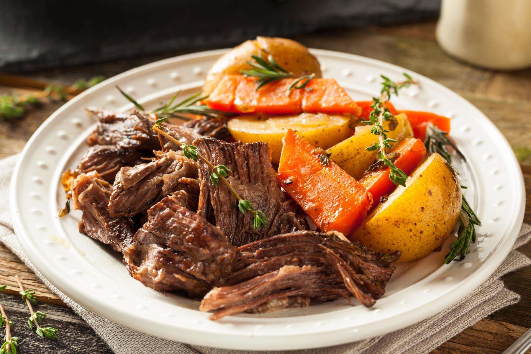Pot roast on plate with vegetables.