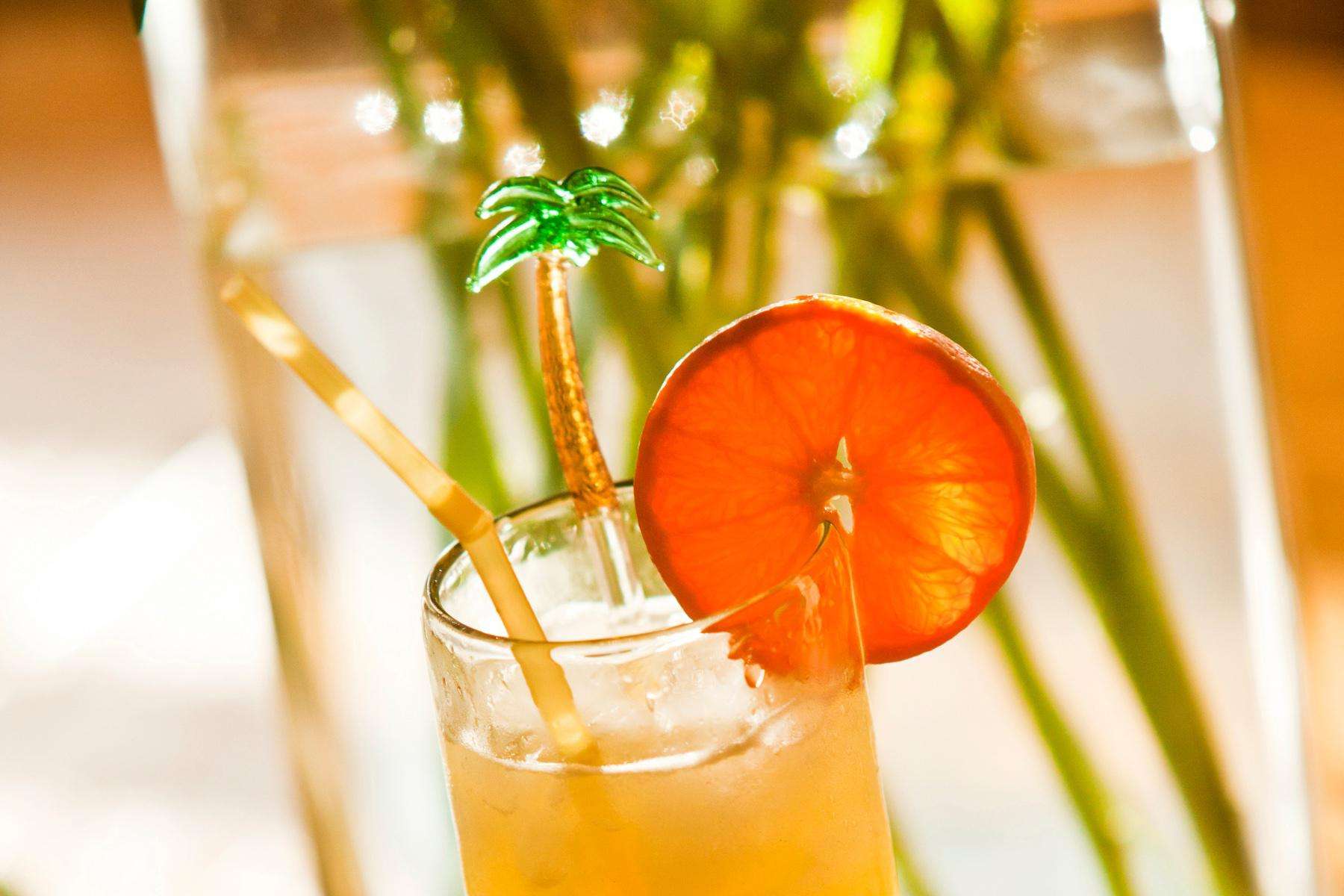 A close-up of an orange ginger cooler with an orange garnish on the rim of the glass.