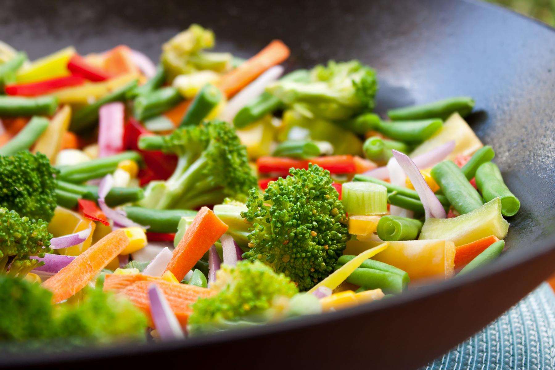 A close-up of a bowl of orange vegetable stir-fry.