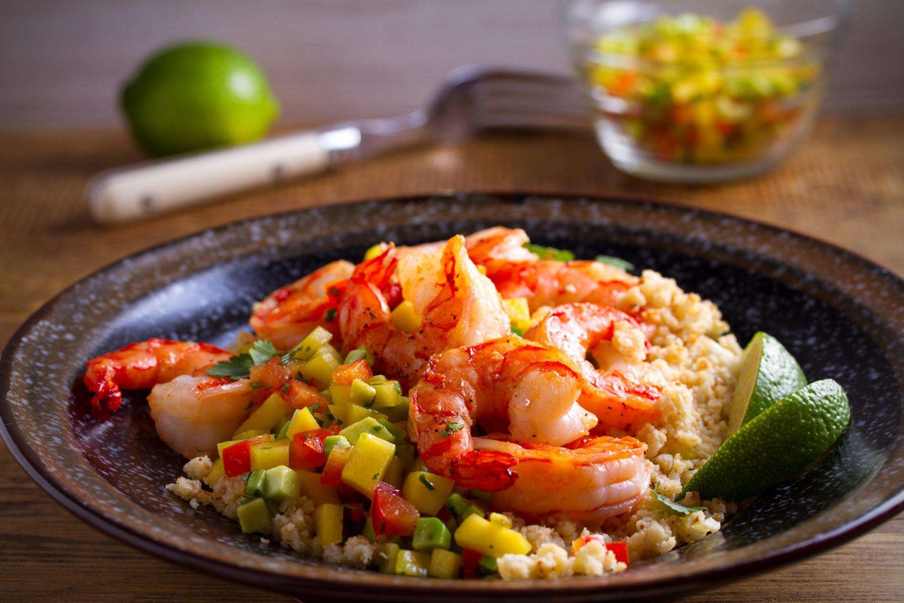 Plate of cooked shrimp on green apple salsa and rice.