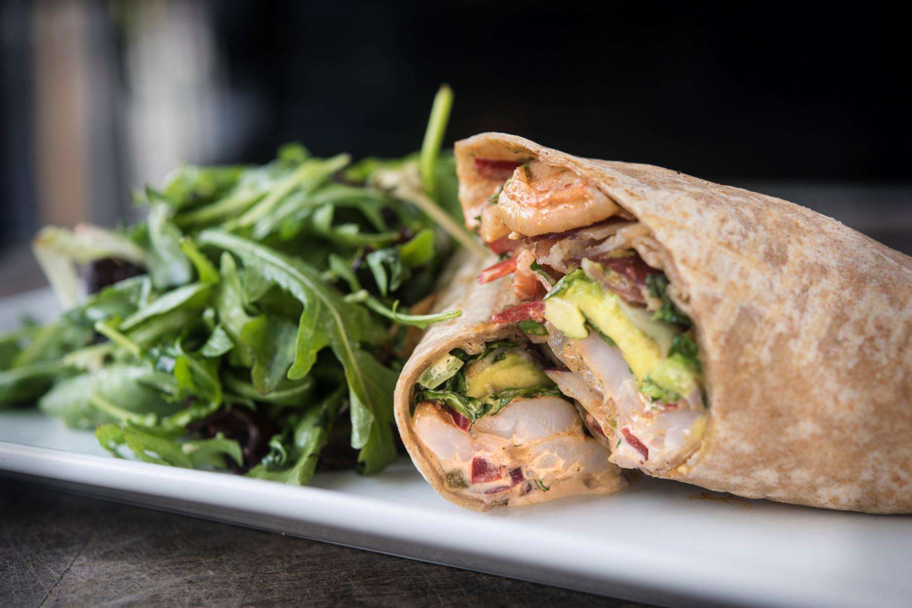Sweet and sour shrimp wrap with a side salad.