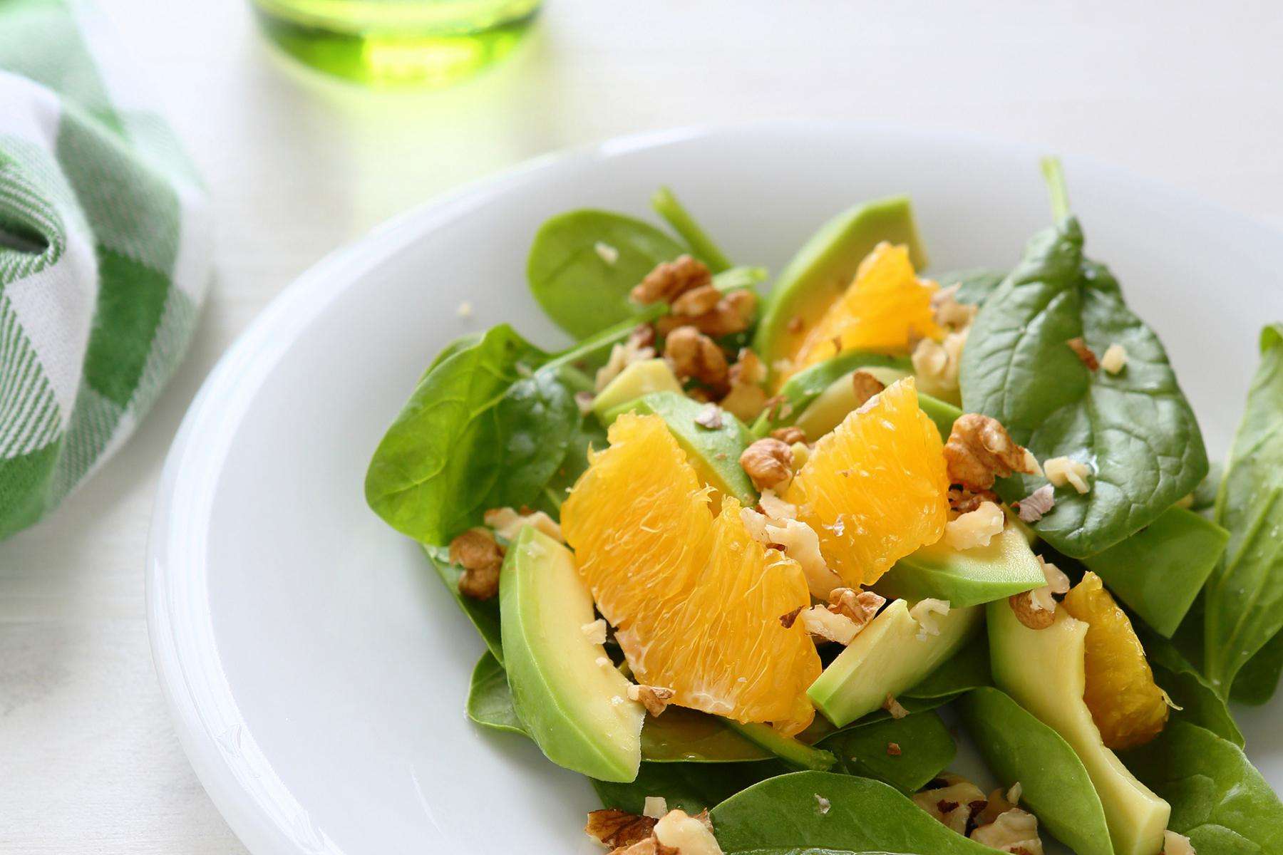 A plate of shrimp with citrus marinade and spinach salad.