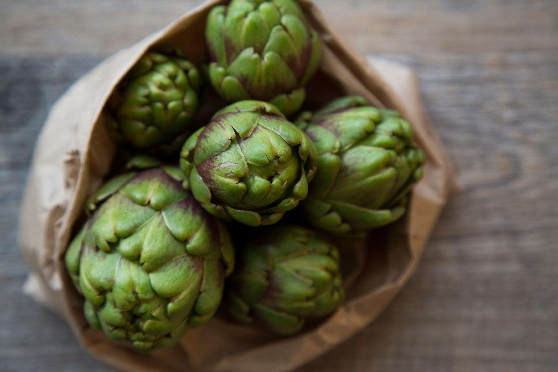 Close-up of artichokes in brown bag.