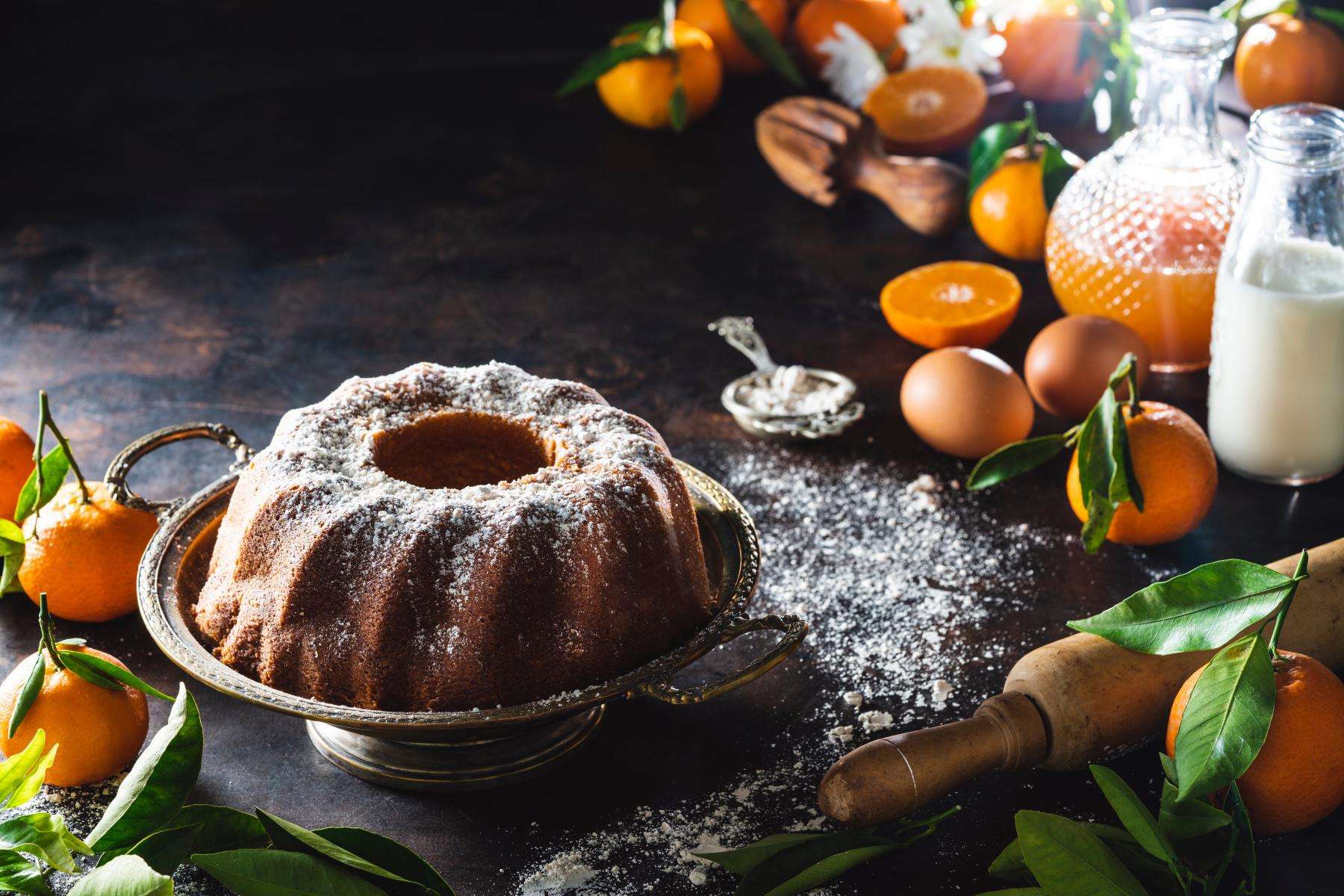 An orange pound cake with powdered sugar sprinkled on top.