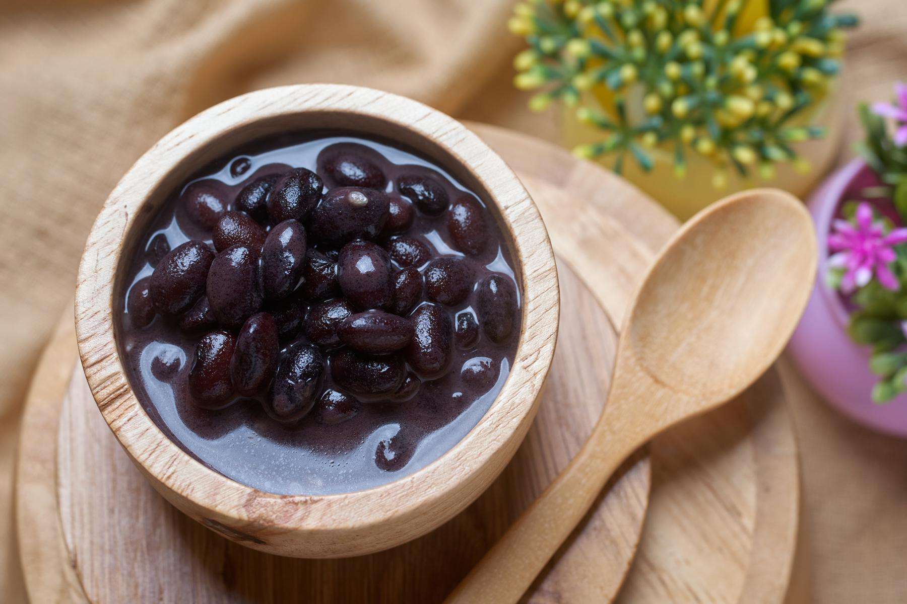 Black beans in a small wooden bowl.