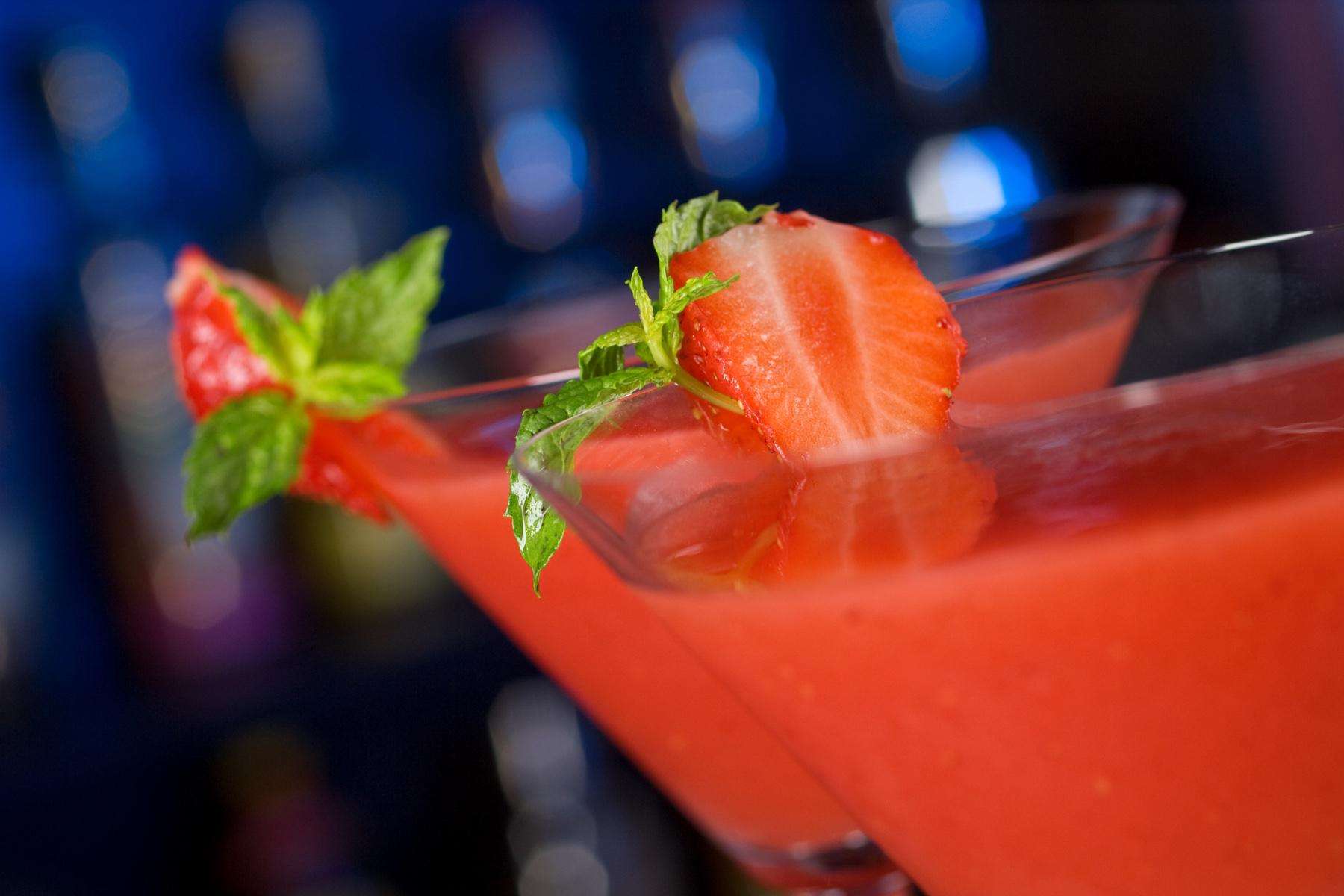 Two strawberry daiquiris in martini glasses.