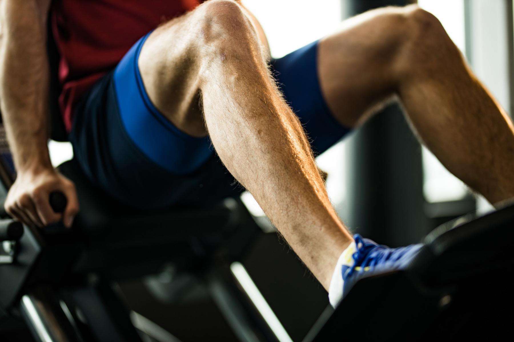 close-up of man's legs on a leg press machine in gym