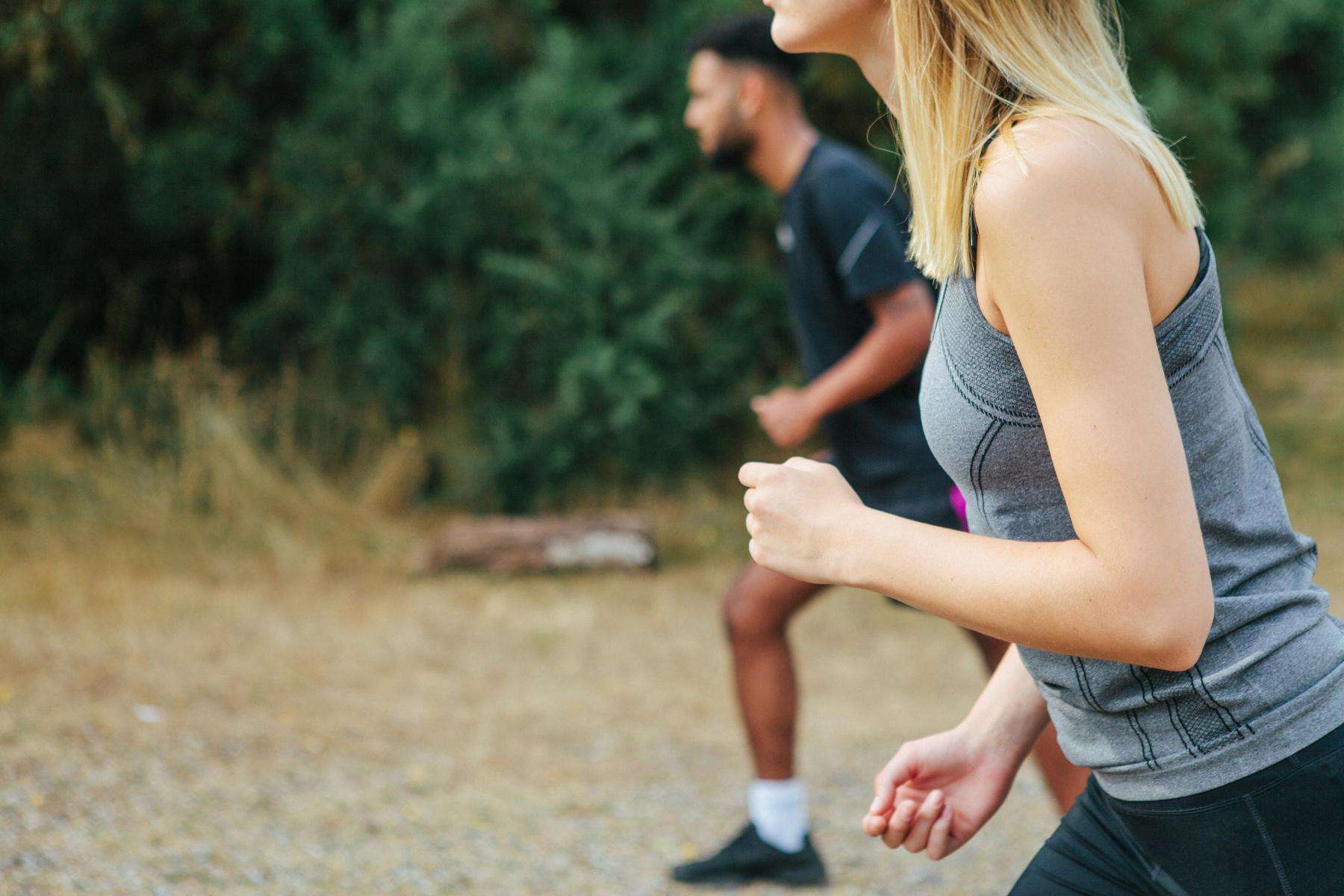 close side view of a man and woman about to run a race