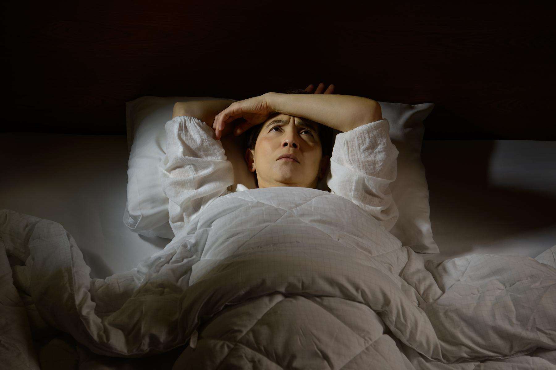 a sleepless woman worrying in bed