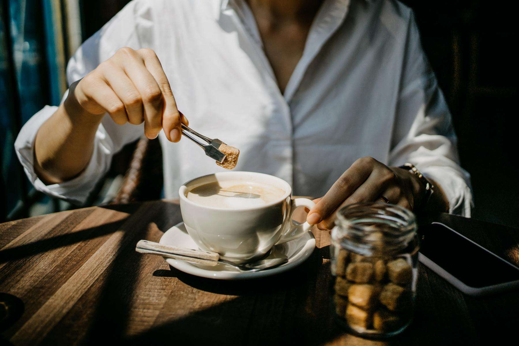 woman dropping star cube into coffee