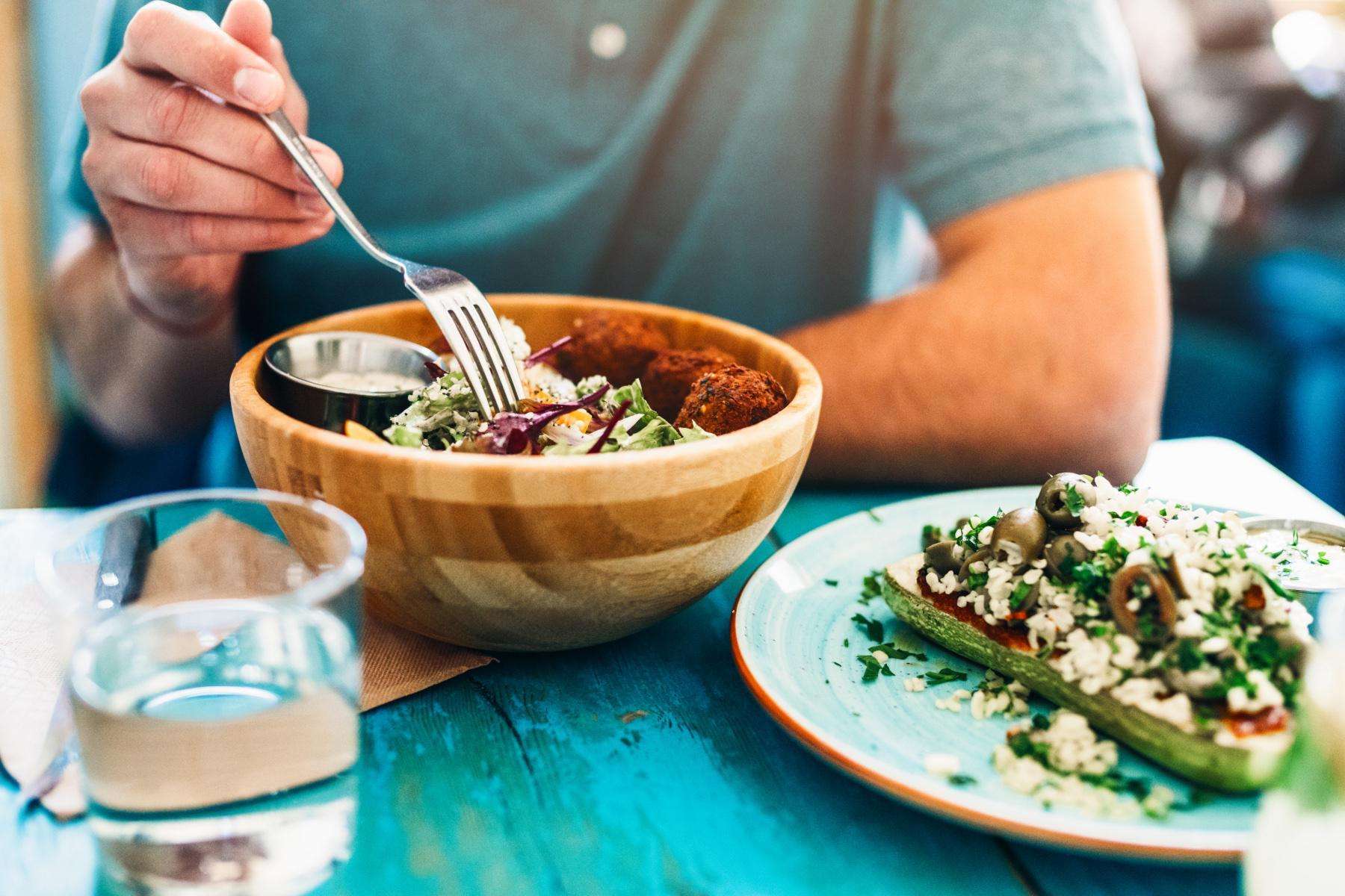 close-up of man with a bowl and plate full of food