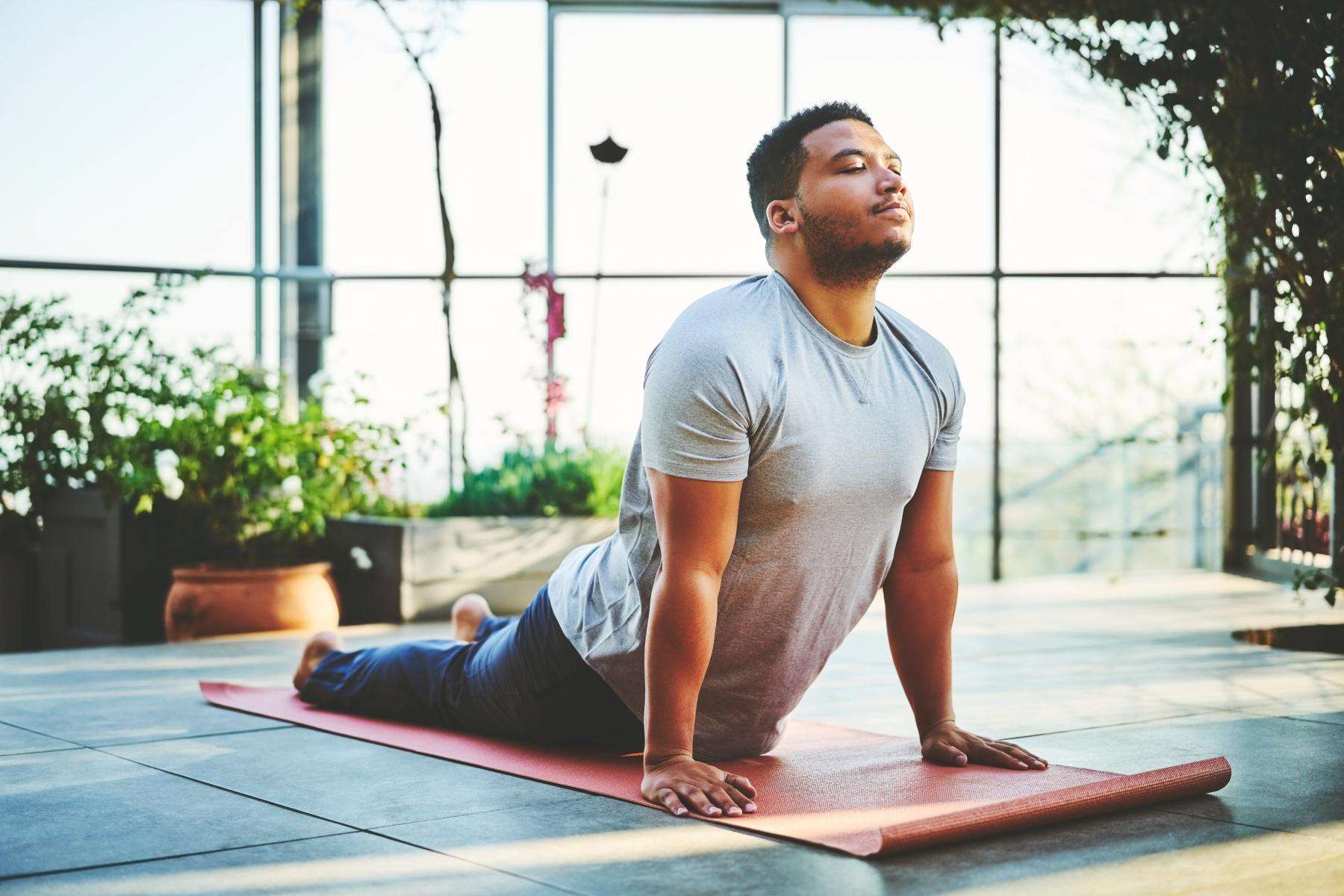 Man on yoga mat in sphinx pose.