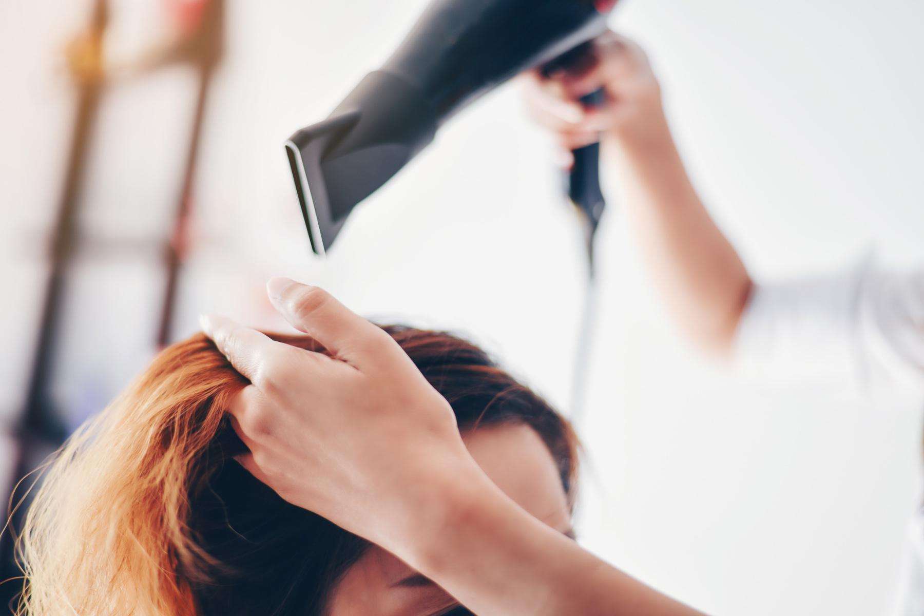 Woman getting her hair blow-dried at a salon.