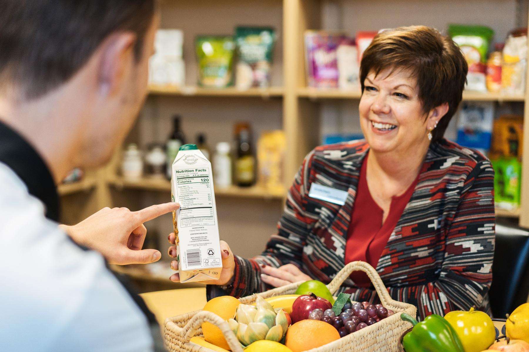 Nutritionist talking to client about box product she is holding.