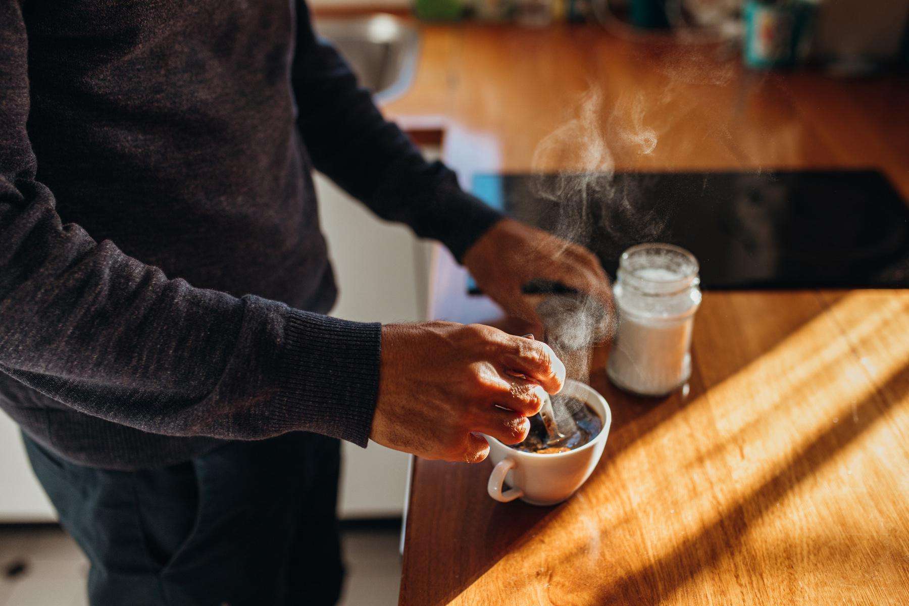 A man making a cup of tea in his kitchen.