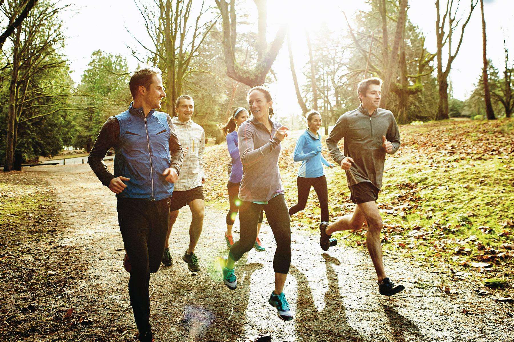 group of men and women running outside in the fall