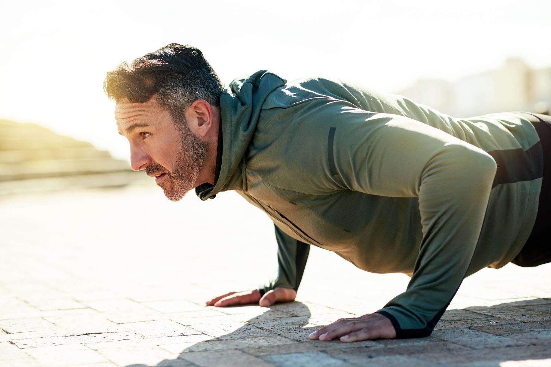 close-up of middle aged man doing a push-up from the side