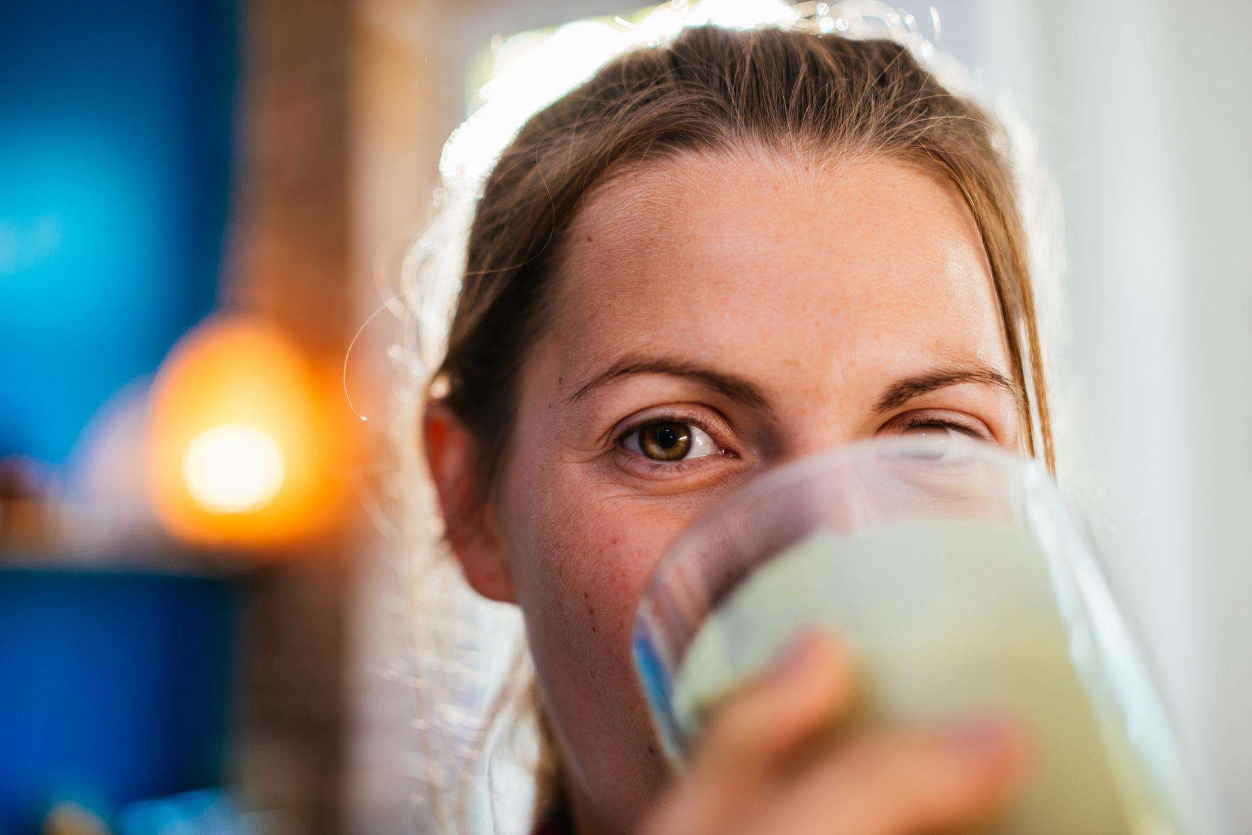 Close-up of woman's face as she drinks smoothie.