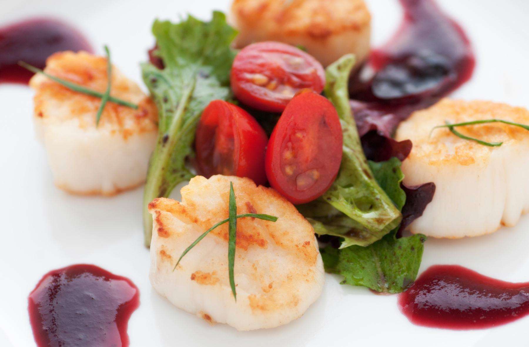 Close-up of seared scallops with cranberry vinaigrette.