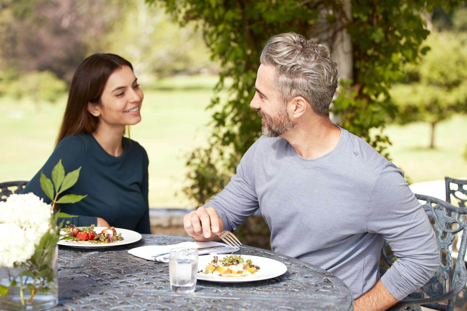couple enjoying meal at outdoor dining table