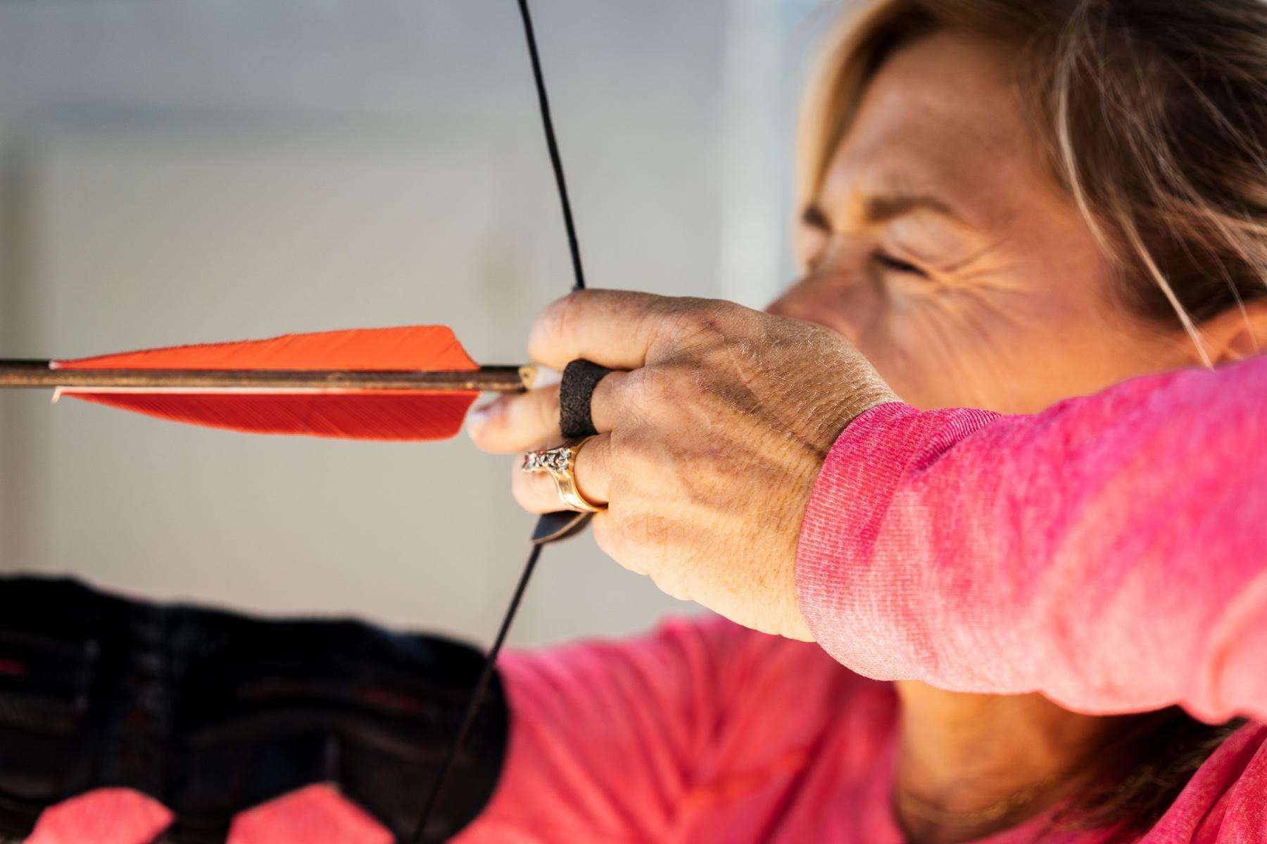 A woman shooting a bow and arrow.