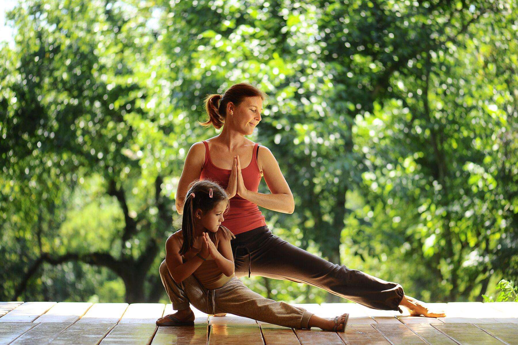 woman and her daughter doing yoga