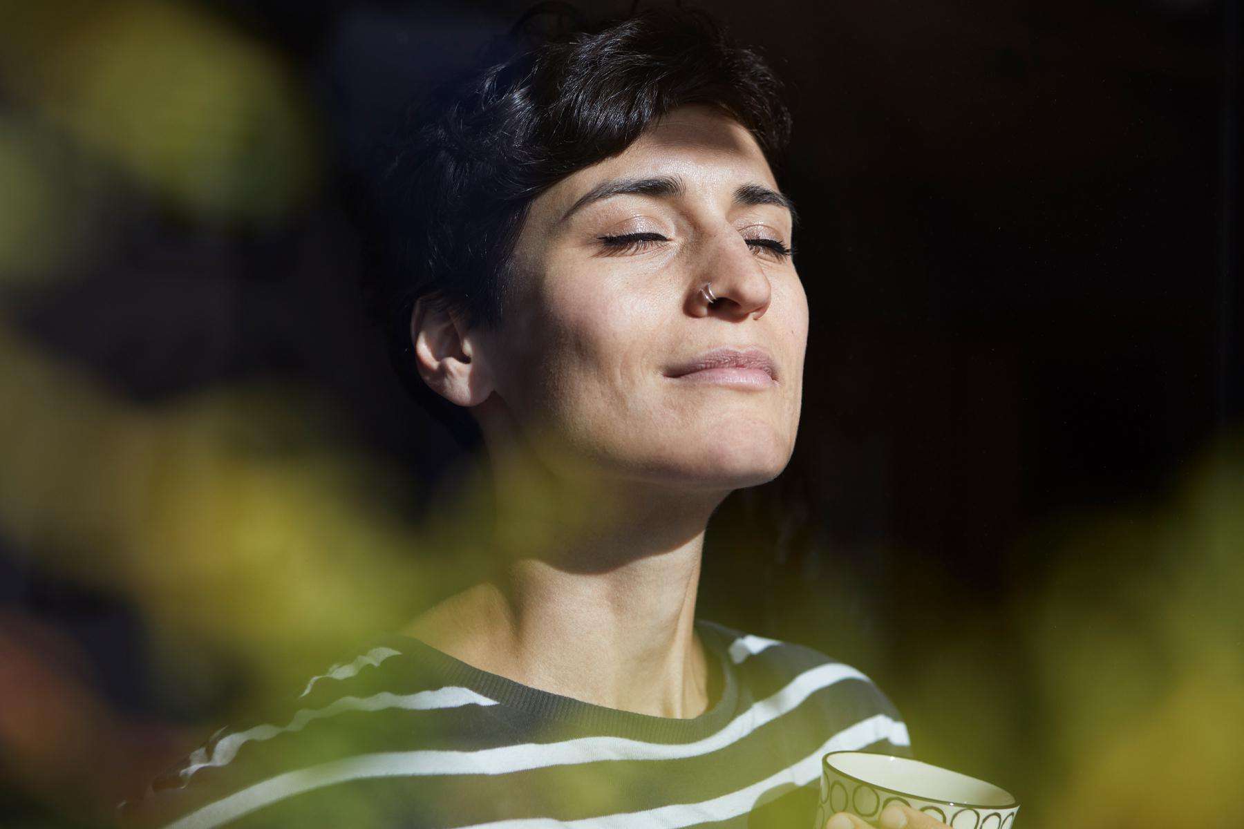 A close-up of a woman breathing in the fresh air.